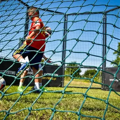 Zawodnik prowadzi piłkę w zamkniętej arenie Football Octagon - intensywny trening na małej przestrzeni.