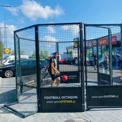 Animator prezentuje grę w arenie Football Octagon podczas wydarzenia promocyjnego.