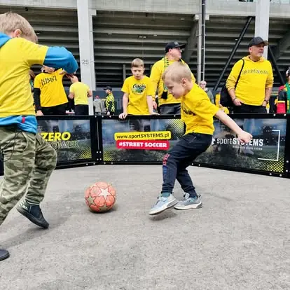 Chłopiec oddaje strzał w Mini Octagon Arena - piłkarskie emocje w strefie kibica.